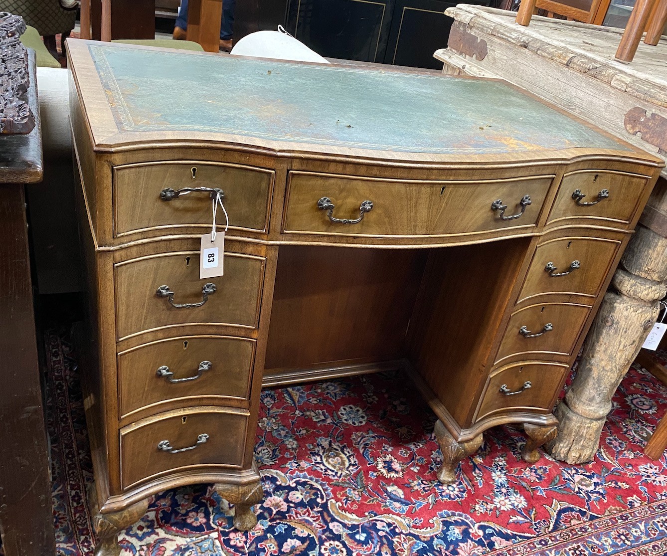 A reproduction George III style mahogany serpentine shaped kneehole desk, length 97cm, width 55cm, height 76cm